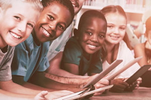 Literacy programs are important, as evidenced by these students reading on tablets in the school library.